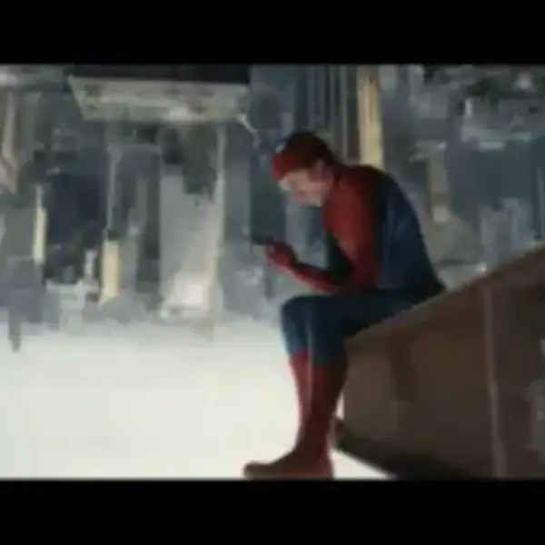 Spider-Man: Brand New Day Spider-Man sits on the edge of a building, looking at a phone. The cityscape appears upside down below, creating a disorienting, contemplative scene.