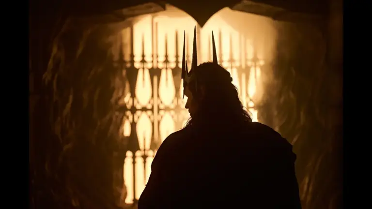 Charlie Vickers in The Lord of the Rings: The Rings of Power (2022), standing in front of a lit, ornate background.