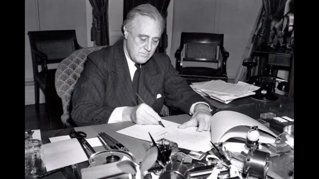 President Franklin D. Roosevelt, half-length portrait, seated at desk, looking down, signing H.R. 1776, the lend-lease bill to give aid to Great Britain, China and Greece.