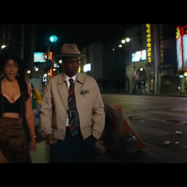 Rosalind Eleazar and Chris Rock walking side by side in Misty Green trailer.