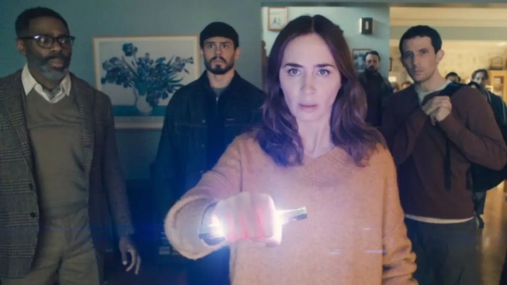 A group of people standing in a room, with a woman holding a flashlight that emits light.