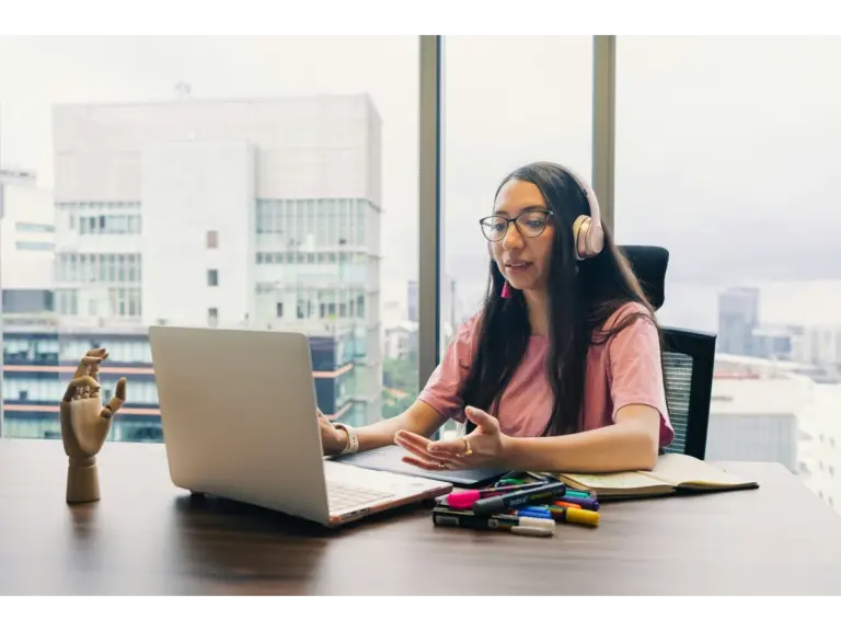 Woman wearing headphones working on a laptop, representing creators behind chaos content.