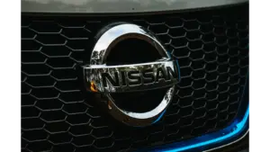 Detailed shot of the Nissan logo on a car grille grid, emphasizing automotive branding and highlighting the iconic identity of the Nissan Altima.