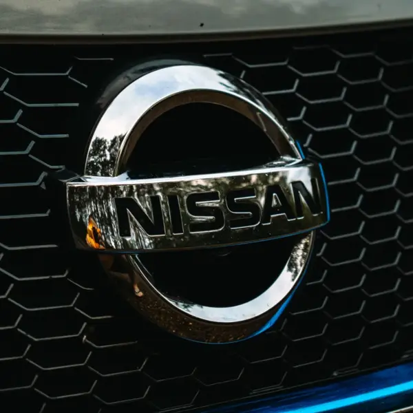 Detailed shot of the Nissan logo on a car grille grid, emphasizing automotive branding and highlighting the iconic identity of the Nissan Altima.