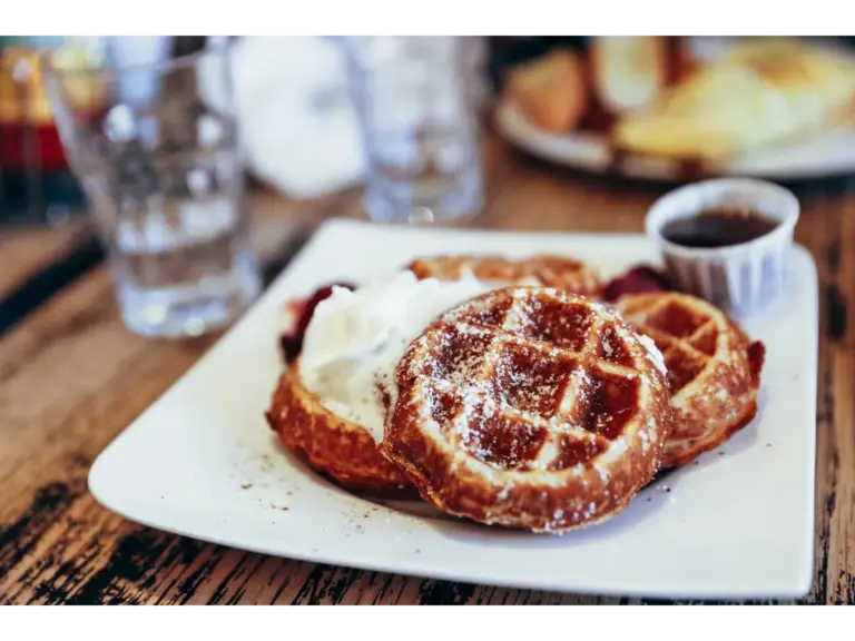 Tempting cinnamon waffles topped with cream and syrup, perfect breakfast delight