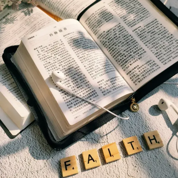 In daily devotilnal, open Bibles are seen with "Faith" spelled out and headphones.