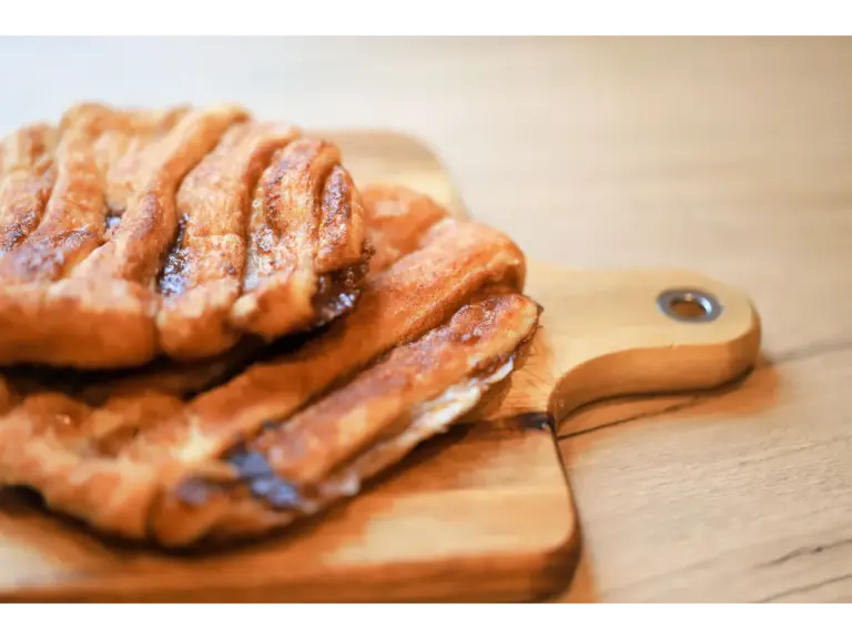 Delicious cinnamon pastry on a wooden board, perfect for sweet lovers diving headfirst into the butter craze.
