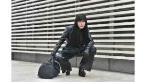 Striking pose of a model in a black leather outfit outdoors, showcasing urban fashion with a bold edge that taps straight into fashion psychology.