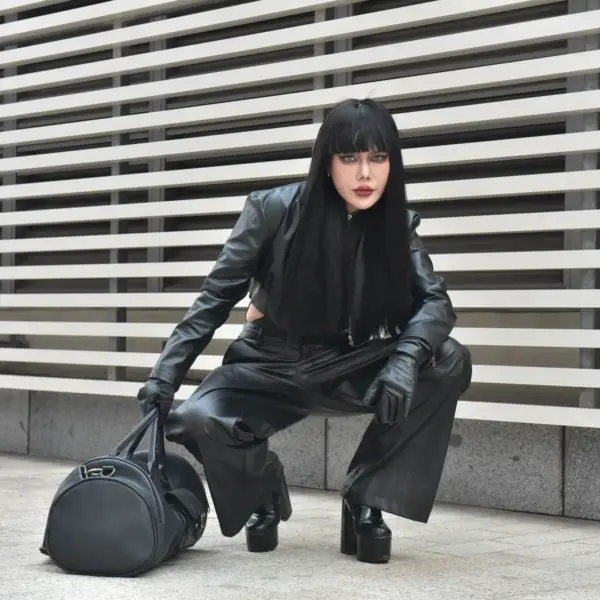 Striking pose of a model in a black leather outfit outdoors, showcasing urban fashion with a bold edge that taps straight into fashion psychology.