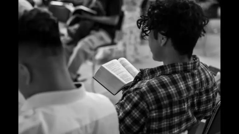 In this daily devotional, a young man is studying the Word of God in a claccroom with others.
