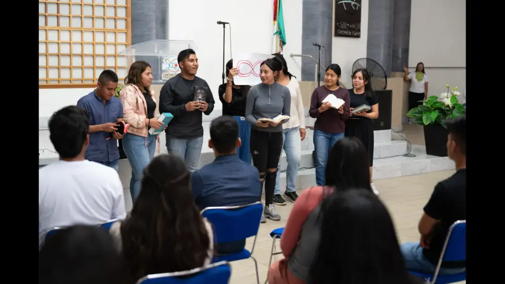 In daily devotional, several people are standing up holding Bibles reading and proclaiming their faith.
