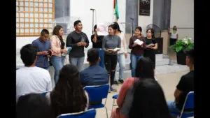 In daily devotional, several people are standing up holding Bibles reading and proclaiming their faith.