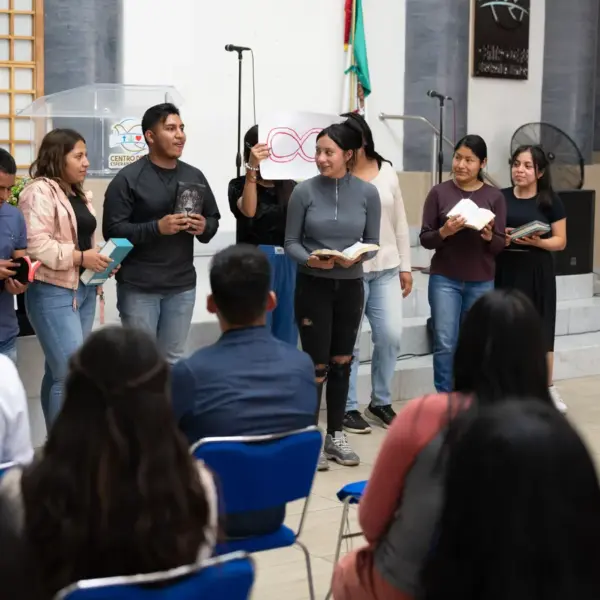 In daily devotional, several people are standing up holding Bibles reading and proclaiming their faith.