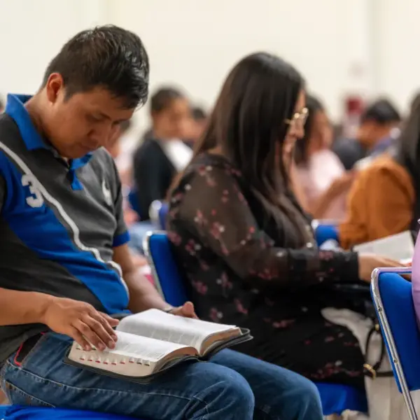 In daily devotional, people are studying the Bible in a classroom setting.