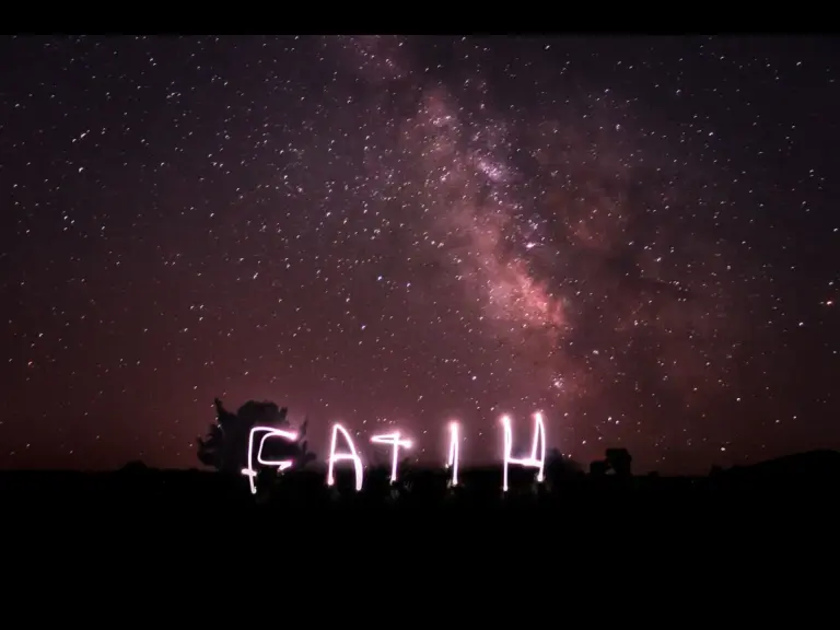 In daily devotional, a neon light sign reads faith against a dark sky.