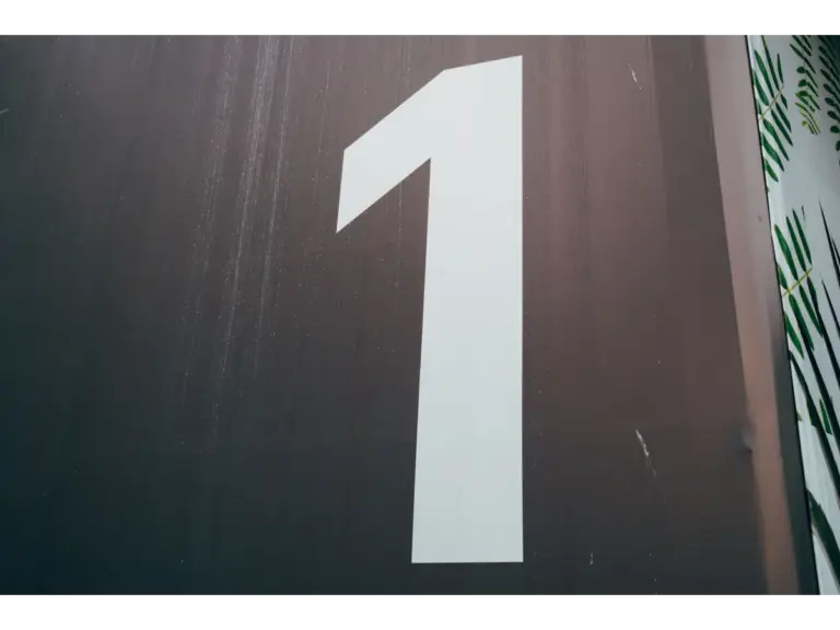 A close-up image of a large white number one painted on a dark wall, subtly echoing dream numbers and their symbolic nighttime meaning.