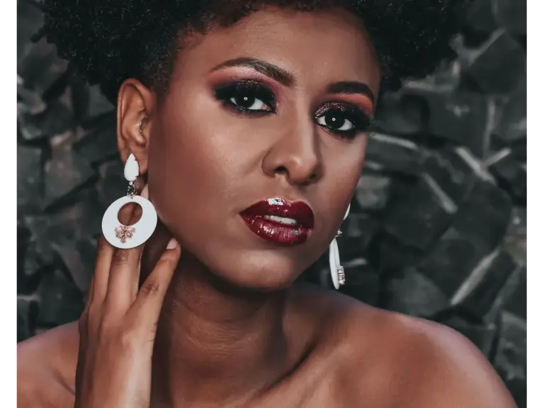 Captivating close‑up portrait of a beautiful woman with striking makeup, red lipstick, stylish earrings, and subtle makeup tricks that elevate her whole look.