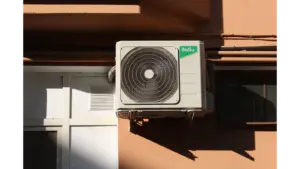 A Ballu air conditioner condenser unit mounted on a building exterior, highlighting efficient home cooling technology.