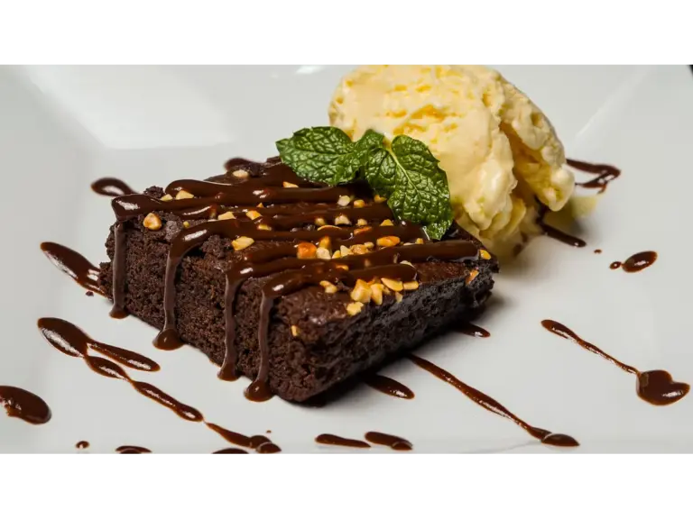 Rich chocolate hot fudge brownie topped with nuts, served with a scoop of vanilla ice cream