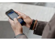 Hands using a smartphone, illustrating the Tsubomi shutdown report