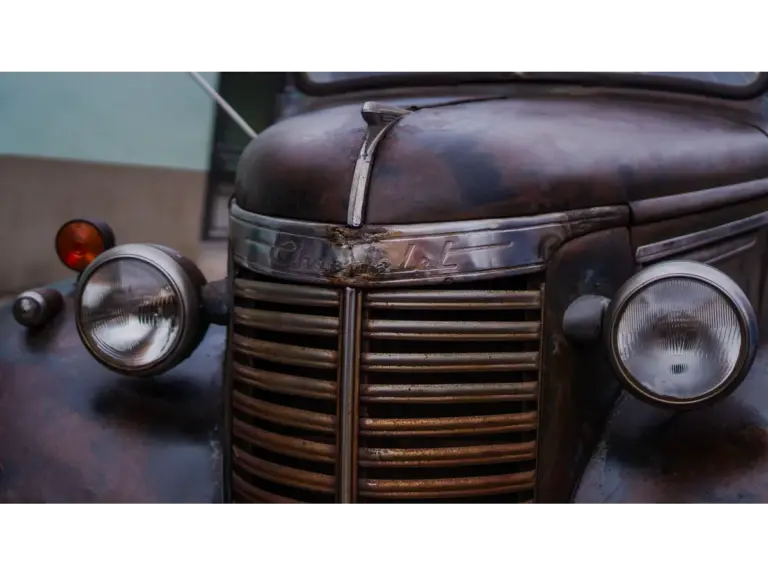  a vintage Chevrolet truck showing its rustic, weathered front view, capturing a gritty real horror vibe through its worn details.