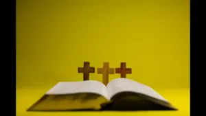 In today's daily devotional, an open Bible is pictured with 3 crosses in the center on a golden yellow background.
