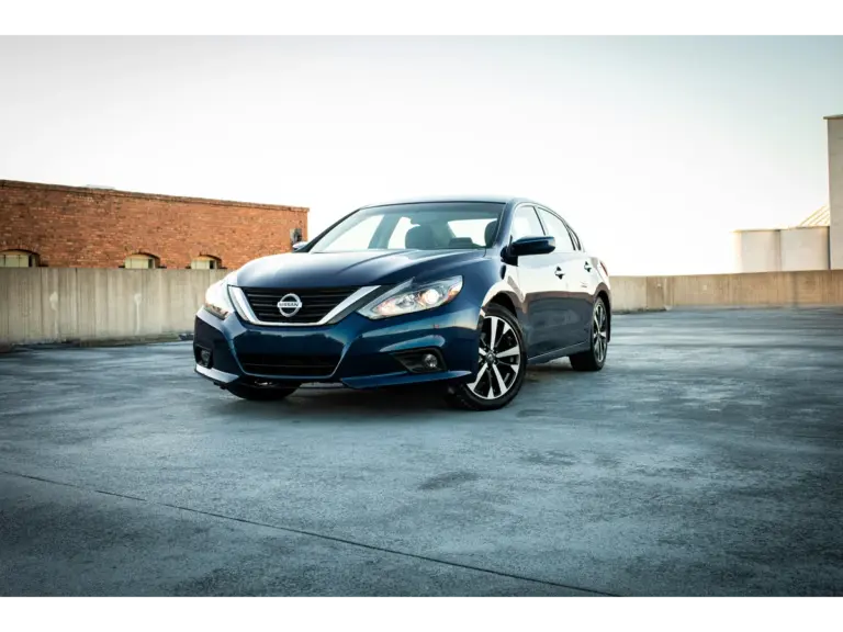 Nissan Altima parked alone in the center of an open space, standing out against the background