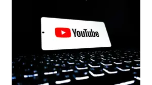 A glowing YouTube logo displayed above a dark, illuminated keyboard, symbolizing the digital world of chaos content and longform storytelling trends.