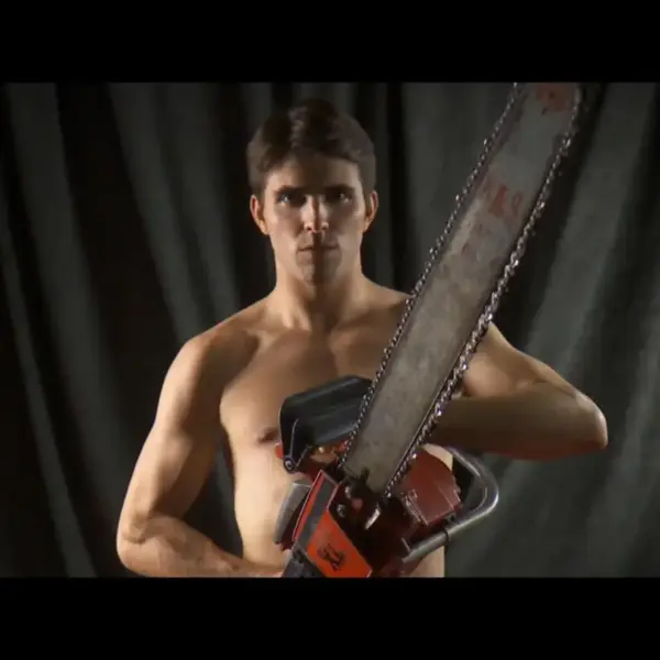 Music videos for "This Must Be The Place (Cover)," featuring Miles Fisher as a shirtless man holding a chainsaw, posing against a dark backdrop.