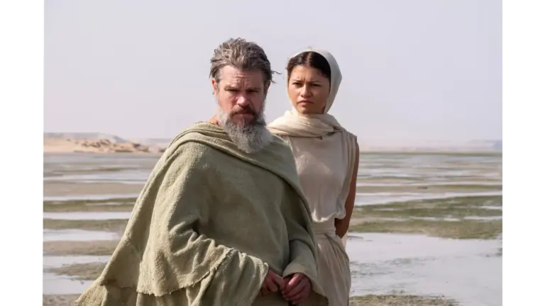 Matt Damon and Zendaya in Christopher Nolan's The Odyssey (2026) in a desolate landscape with shallow water.