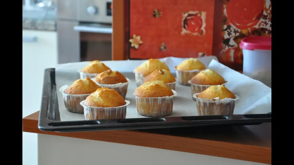 A tray of freshly baked muffins sitting on a kitchen counter. mini muffins, breakfast