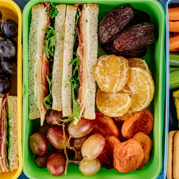 Colorful lunchbox filled with sandwiches, fresh fruits, and vegetables, perfect for a healthy meal and ideal for easy school lunches.