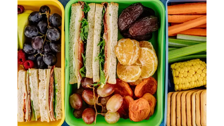 Colorful lunchbox filled with sandwiches, fresh fruits, and vegetables, perfect for a healthy meal and ideal for easy school lunches.