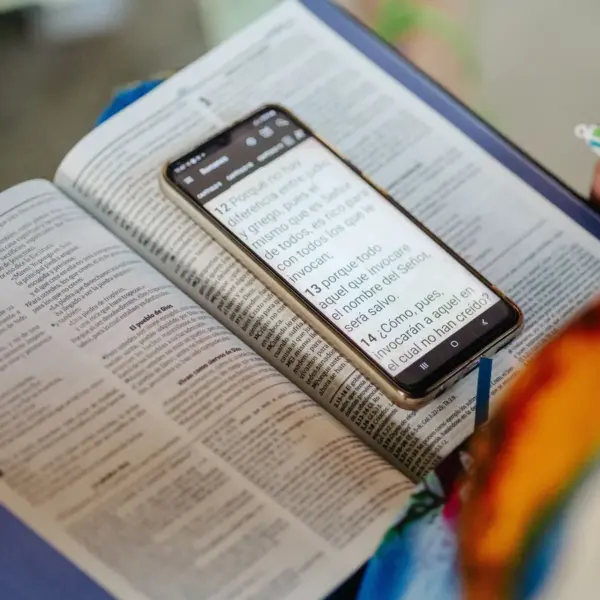 In Thursday's daily devotional, a study area with an open Bible and phone is prepared for someone.