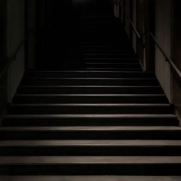 mystical stairs enveloped in darkness, featuring a subtle hint of set hauntings in the shadows.