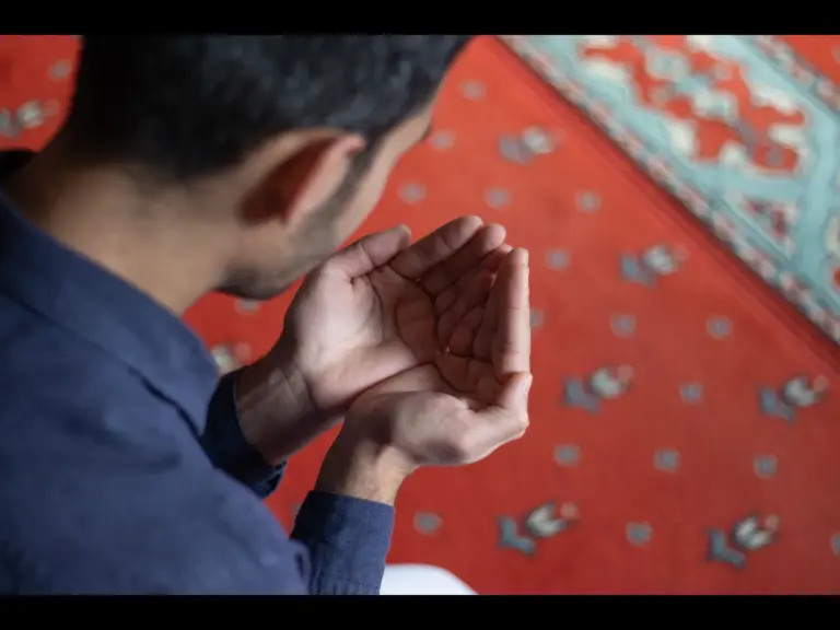 In Friday's daily devotional, a man bows in humility to God as he prays with hands uplifted.