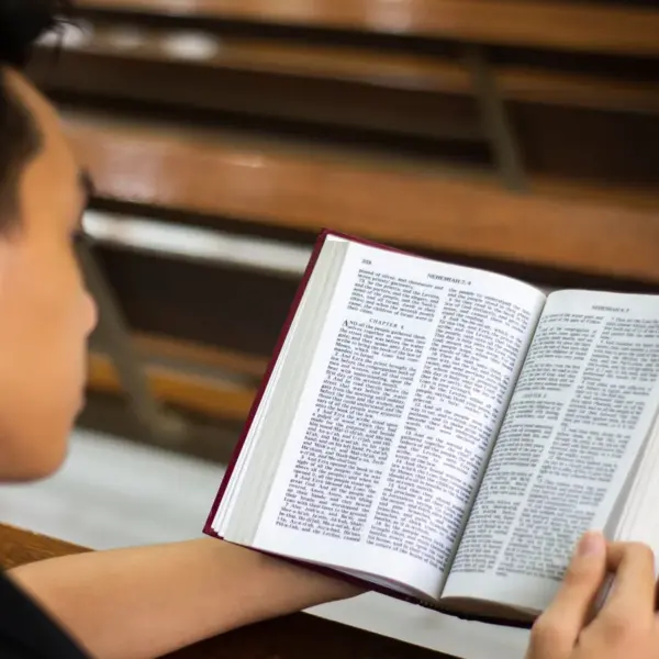 In Monday's daily devotional, a young man reads the Bible while sitting in solitude.