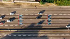 Overhead view of cars on Atlanta’s I‑85 and I‑75 highways on a sunny day, highlighting busy travel patterns influenced by changing gas prices.