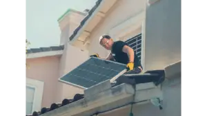 A technician in protective gear installs solar panels on a house roof, promoting sustainability and reflecting the growing housing trends pushing buyers toward smarter, energy‑efficient homes.