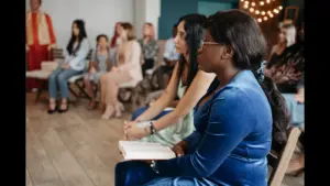 In Monday's daily devotional, a group of people are listening to Bible teaching with open Bibles in hand in a church setting.