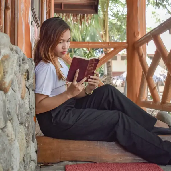 In Tuesday's daily devotioinal, a young woman reads the Bible intently as she relaxes in a home nook.