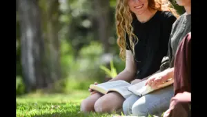 In Tuesday's daily devotional, two young women study the Bible outside in beautiful landscape.