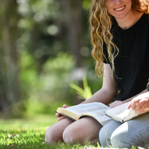 In Tuesday's daily devotional, two young women study the Bible outside in beautiful landscape.