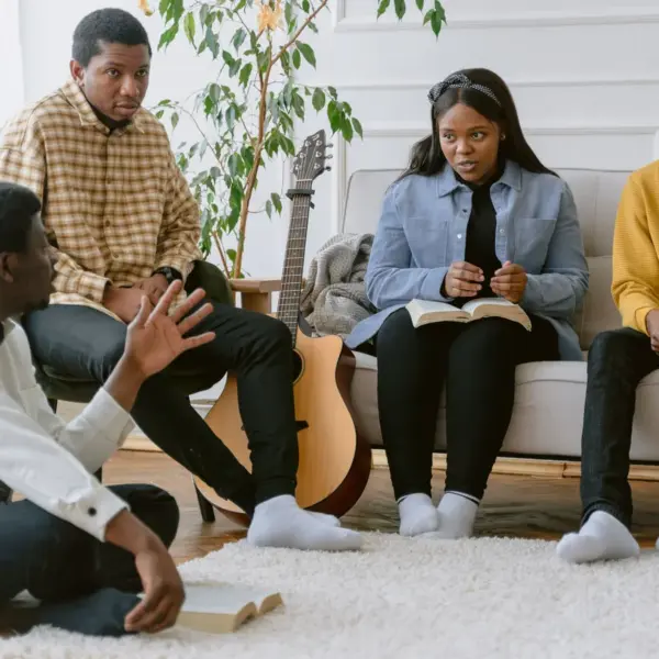 In Friday's daily devotional, a group of young adults is studying the Bible together in a home setting.