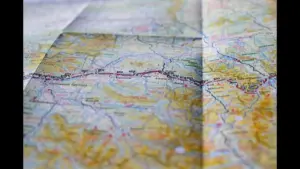A close-up view of a folded map, showing various geographical features, roads, and labels. Labor Day 2026 road trip routes