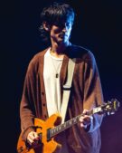 Nick Valensi plays guitar onstage with The Strokes during a New Year's Eve 2019 concert