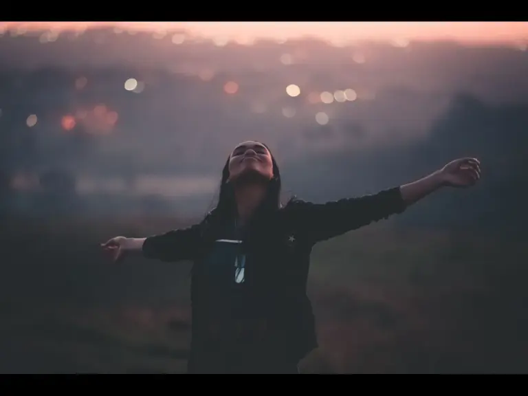 In Monday's daily devotional, a woman with outstretched arms basks in God as a deliverer.