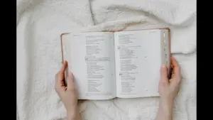 In Friday's daily devotional, a woman's hands are shown holding an open Bible as if reading or studying.