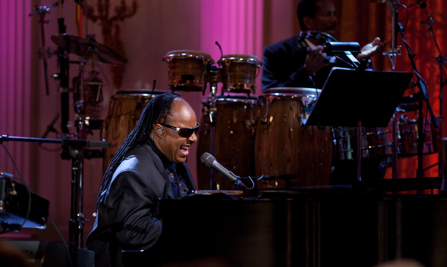 Stevie Wonder, whose Songs in the Key of Life turns 50, sings at a piano during a White House performance