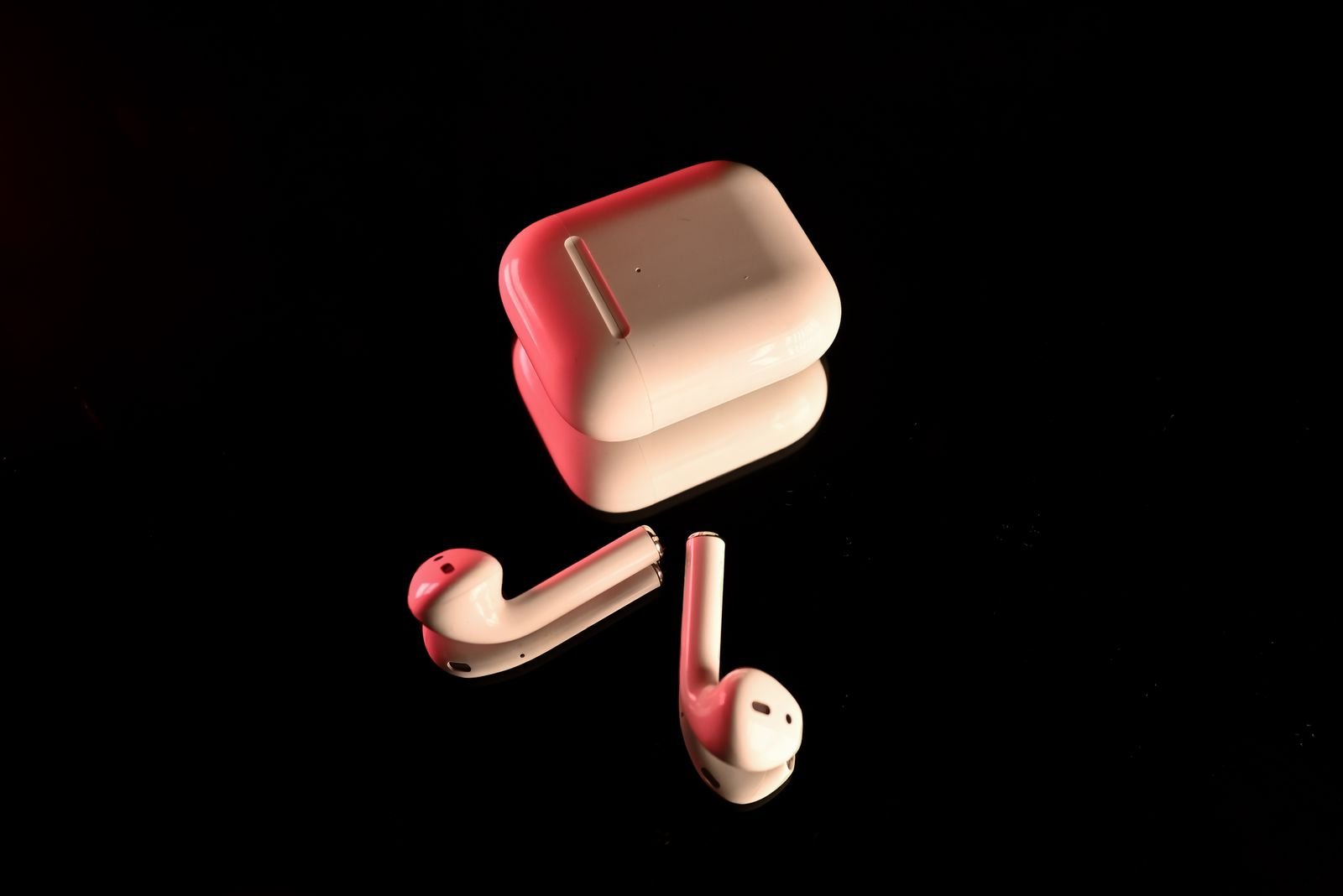 White true wireless earbuds and charging case on a black background, the type of product AVIOT is selling as the 96Neko earbuds